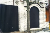 Для возведения опор забора и арки дверного портала применён белый фактурный кирпич